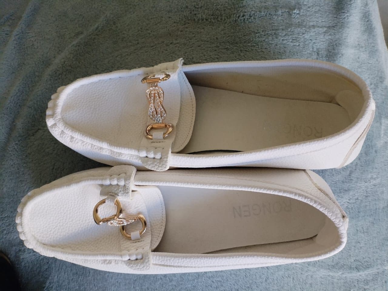 White pebbled loafers with gold and diamante buckle